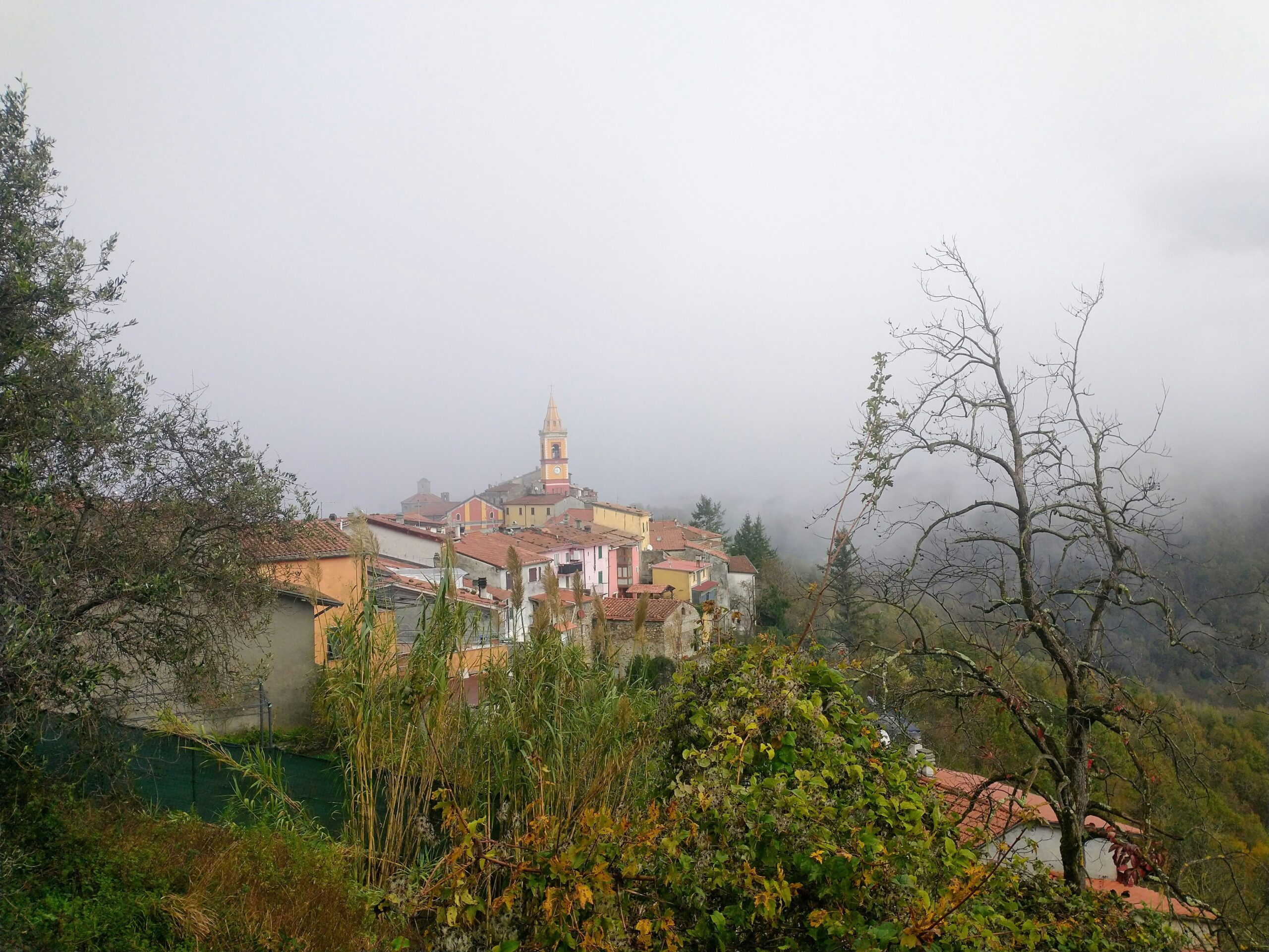 a village on a hill with a church in the background